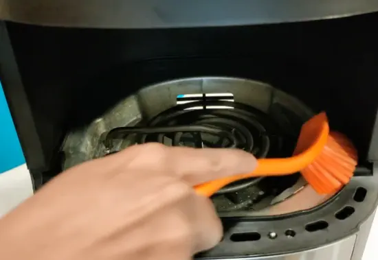 using brush to clean air fryer heating element